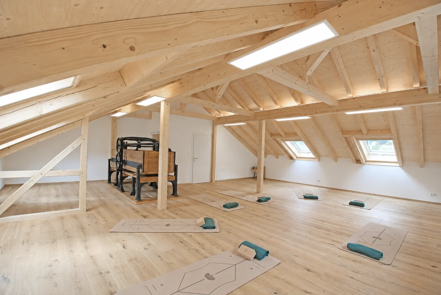 Yogaraum mit historischer Mangel und vorbereiteten Matten