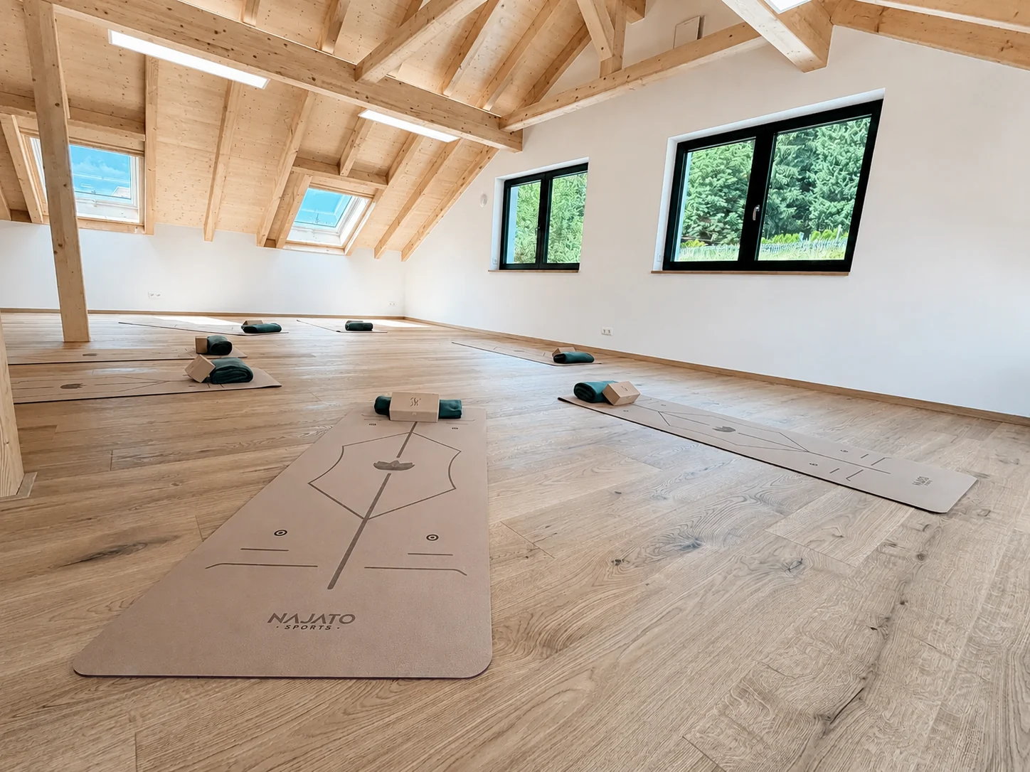 Lichtdurchfluteter Yogaraum mit vorbereiteten Matten